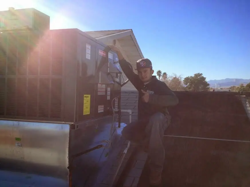 HVAC technician performing Heat Pump Repair on a rooftop unit in West Fargo